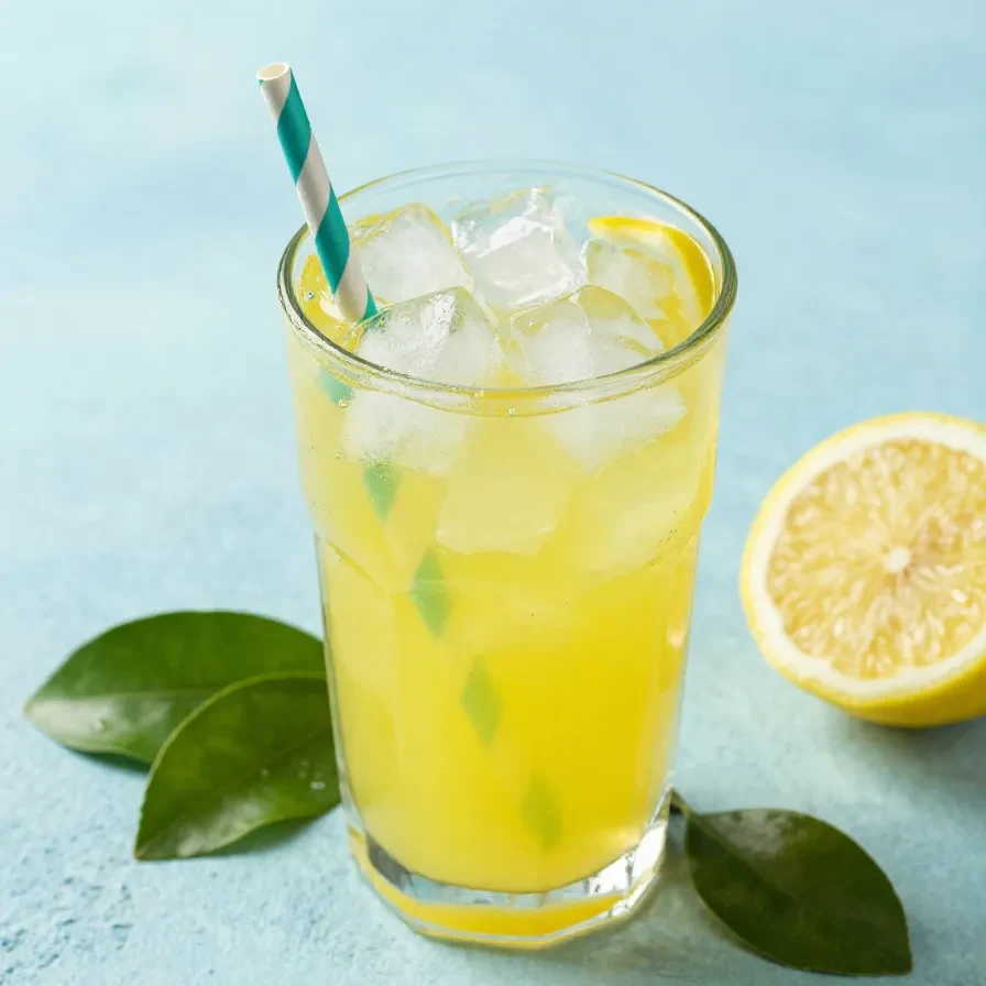 A glass of homemade Chick-fil-A style lemonade with fresh lemon slices and ice cubes on a wooden table.
