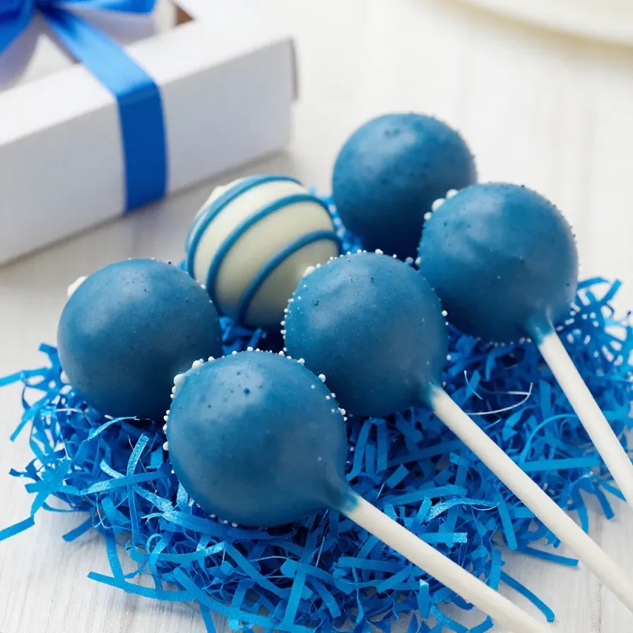 A close-up of colorful Father's Day cake pops decorated with ties and mustaches.